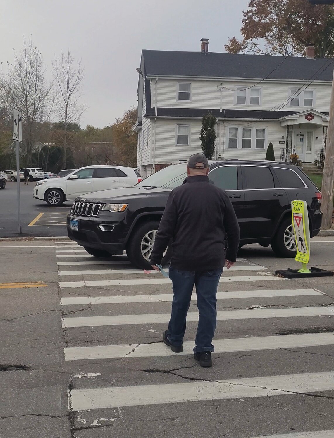 CLOSE CALL: Pedestrians attempt to cross Atwood Avenue outside St. Rocco Church following the school’s Veterans Day prayer service on Friday. A driver narrowly missed several people in the crosswalk after failing to yield. Johnston Police cited the driver, based on video captured by the Johnston Sun Rise.